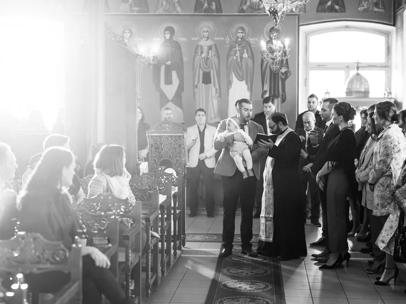 Familie und Priester während der Taufzeremonie im Kirchenraum