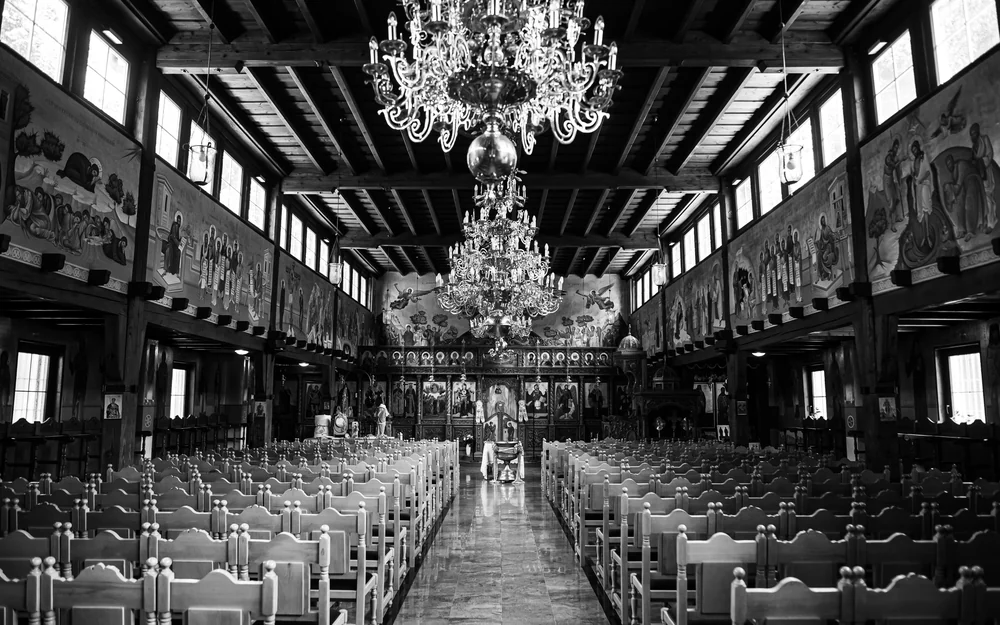 Leerer orthodoxer Kirchenraum mit Ikonen und Kronleuchtern