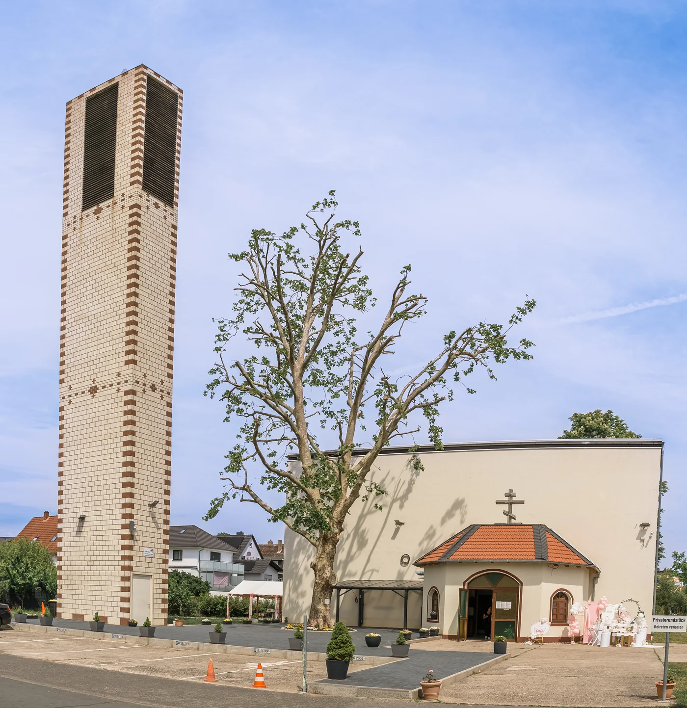 Griechisch-Orthodoxe Kreuzerhöhungskirche in Rüsselsheim mit freistehendem Kirchturm und Vorplatz