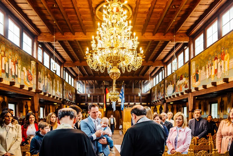 Familie mit Priester im Innenraum der Kirche Christi Himmelfahrt in Stuttgart-West - Taufe Fotograf Stuttgart