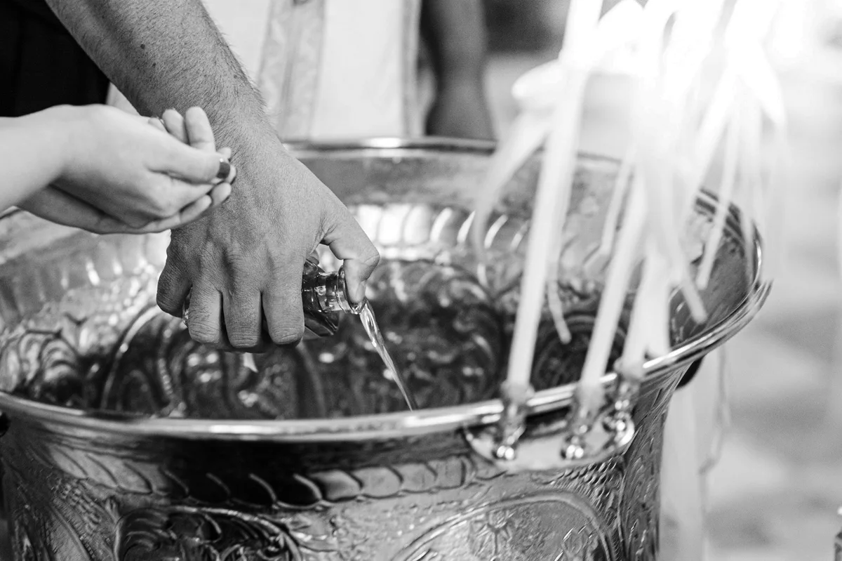 Priester betet über dem Taufbecken bei der Wassersegnung - Taufe Fotograf Stuttgart