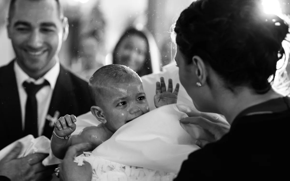 Kind nach dem Untertauchen bei orthodoxer Taufe wird von Patin gehalten - Taufe Fotograf Stuttgart