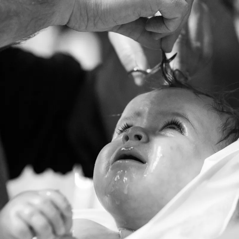 Haarsträhne wird kreuzförmig geschnitten bei orthodoxer Taufe - Taufe Fotograf Esslingen
